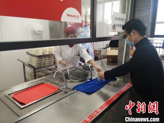 员工领取预防中药汤剂。 刘曼 摄 员工领取预防中药汤剂。 刘曼 摄