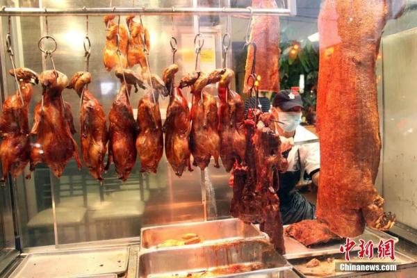 图为多伦多唐人街，一家中餐馆的厨师正在切烧味。 余瑞冬 摄 